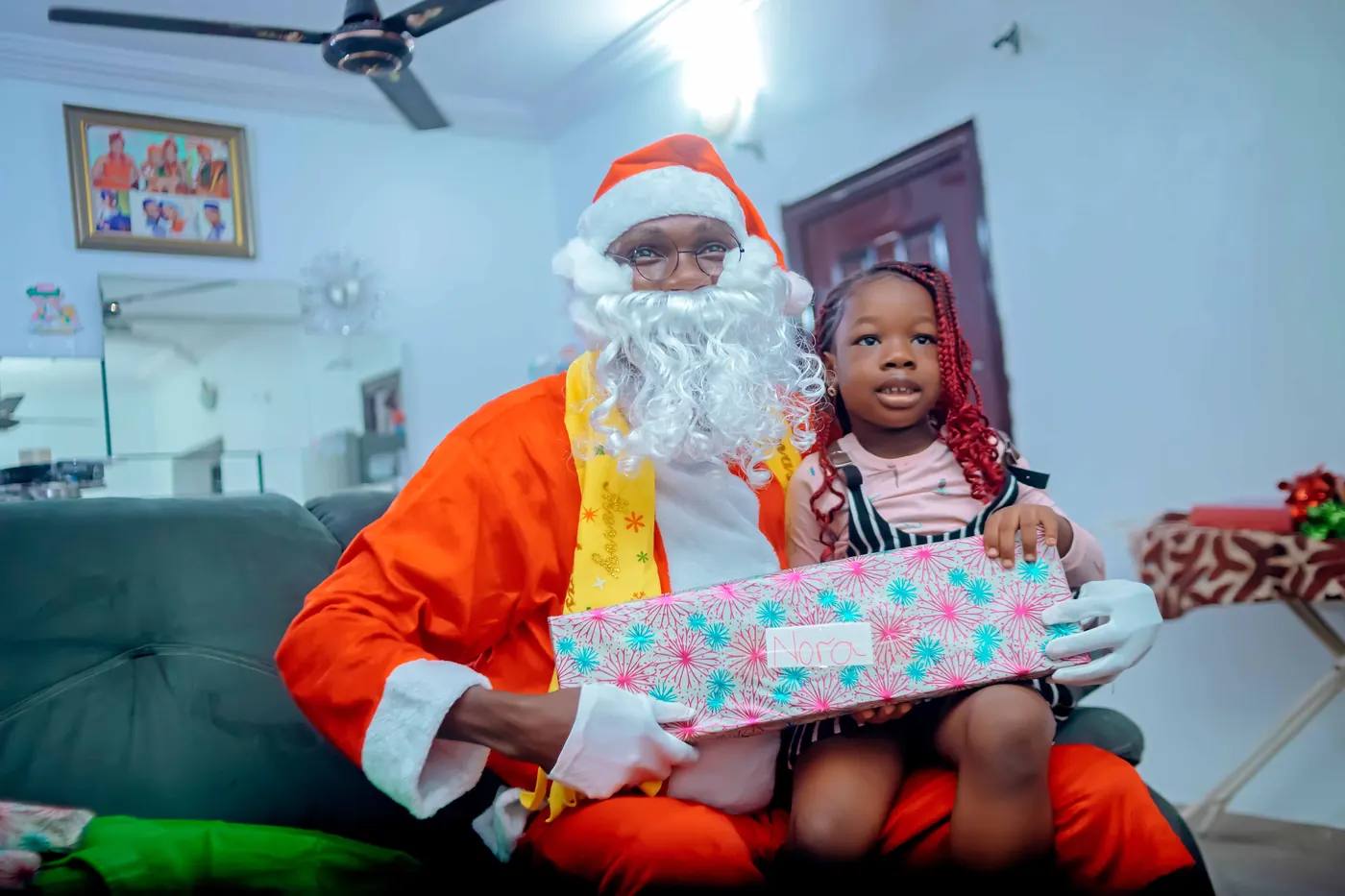 A pupil holding a wrapped gift beside Father Christmas