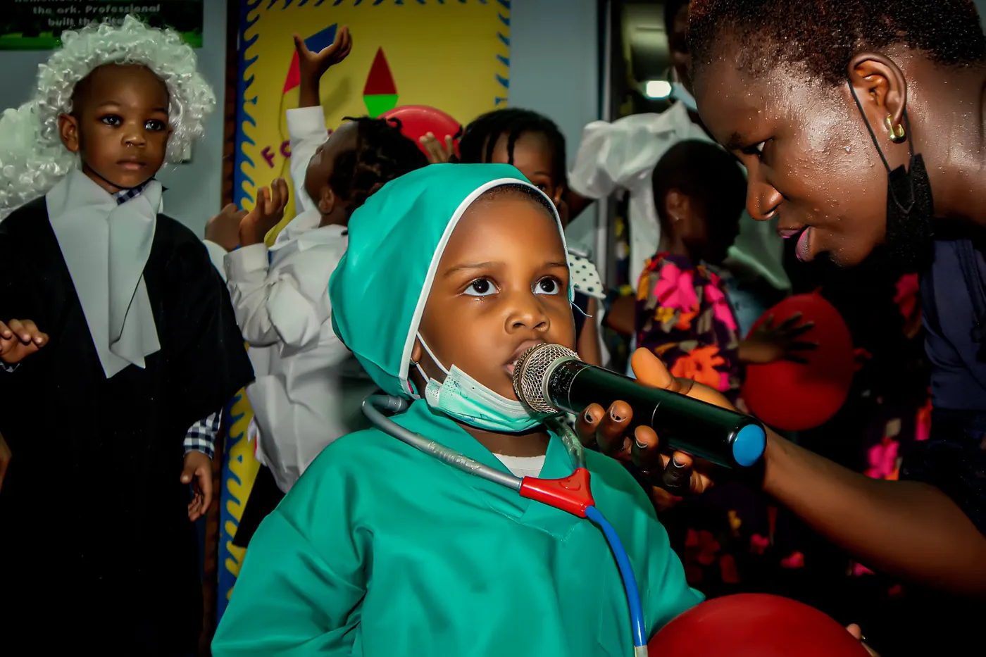 A toddler dressed as a surgeon speaking into a microphone