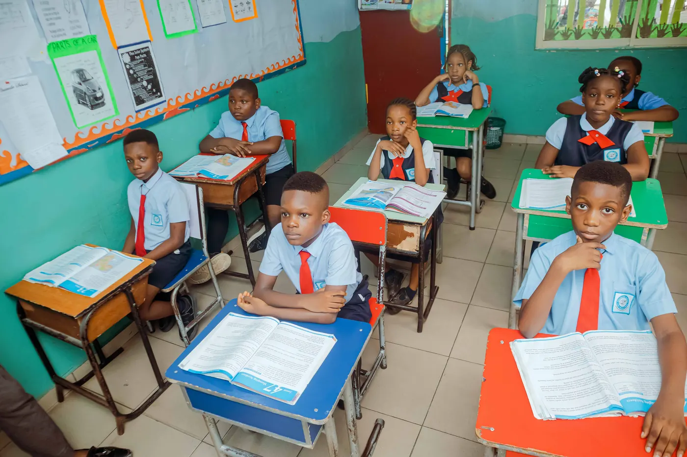 Primary pupils in red ties working through their textbooks